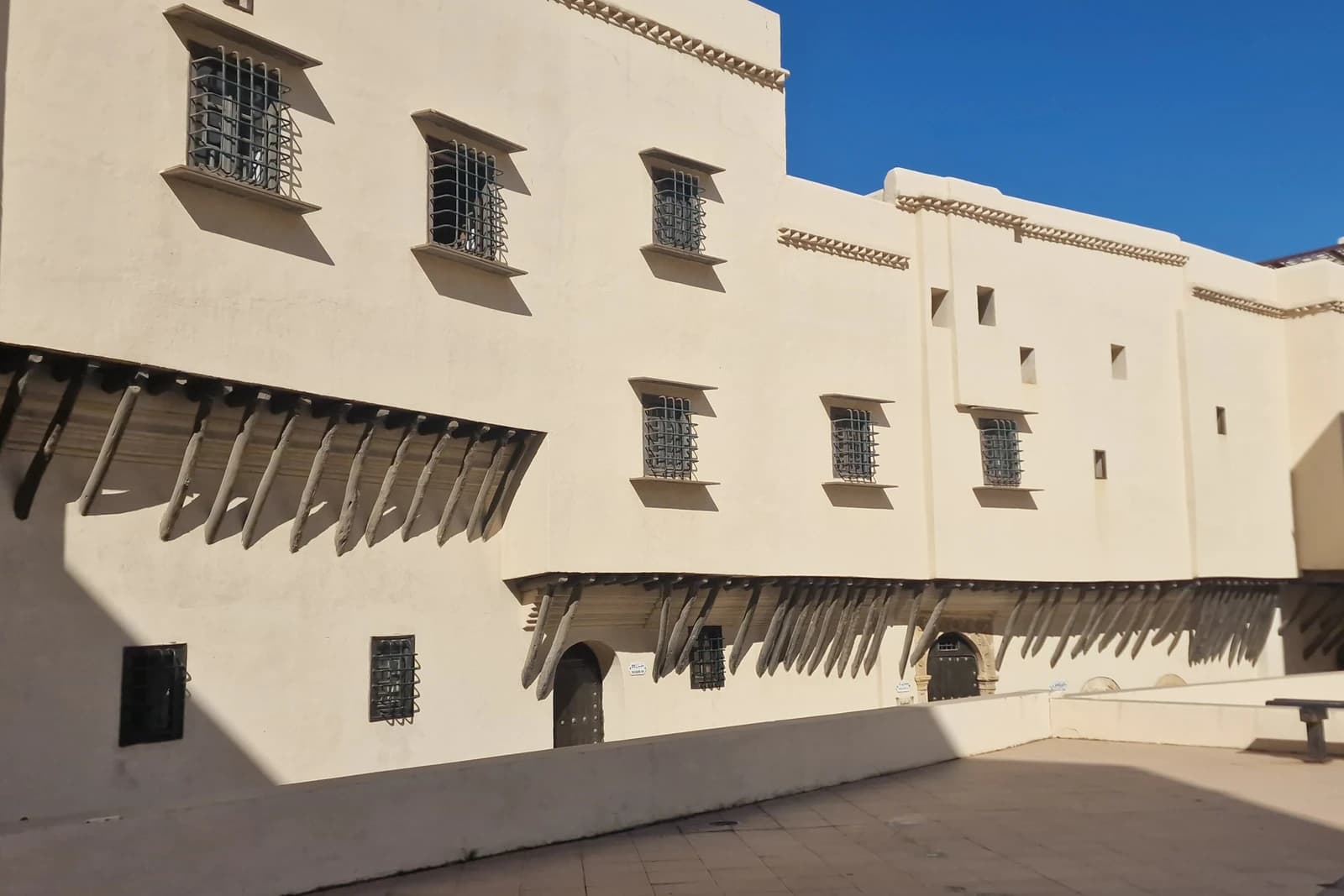 La cour du Bastion 23 (Palais des Raïs), murs blancs et auvents de bois.